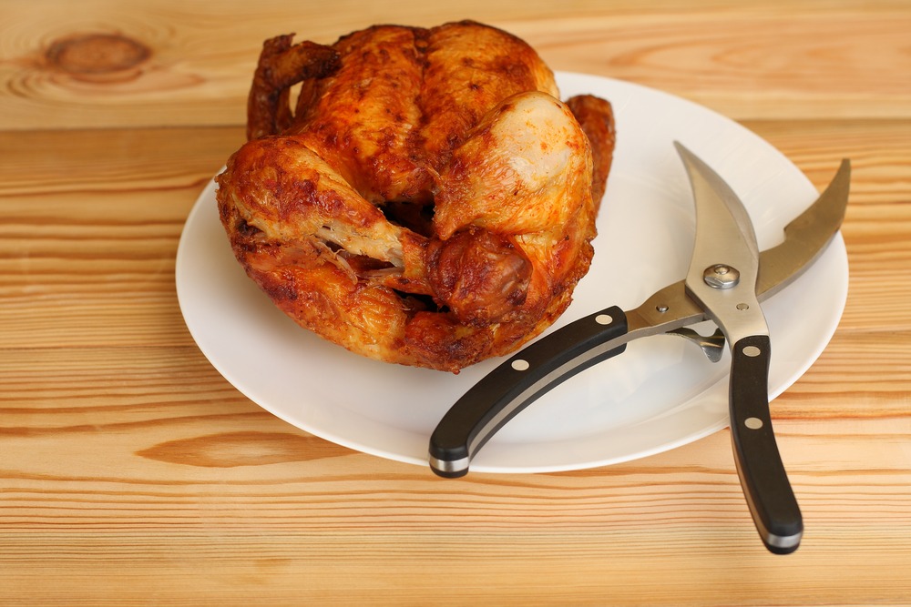 cooked meat and and cutting tool in a plate on a wooden table